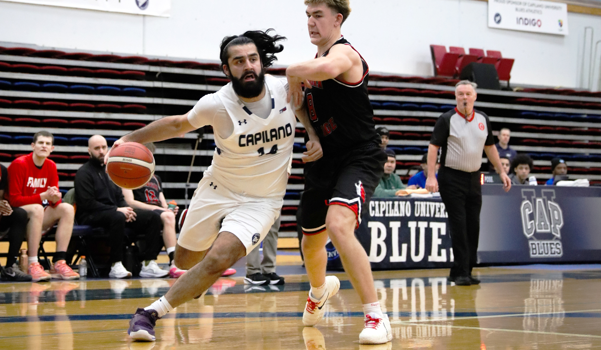 Sukhraj Garcha drives past Okanagan College's Kiyo Brown as part of a 94-72 Blues home win Jan. 16. (Braeden Yu photo)