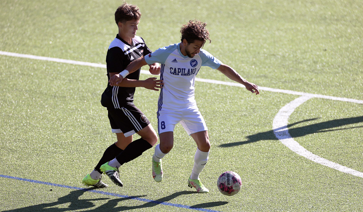 Adrian Sahagun battles a Langara College defender for the ball. (Photo courtesy of Vancouver Sports Pictures)
