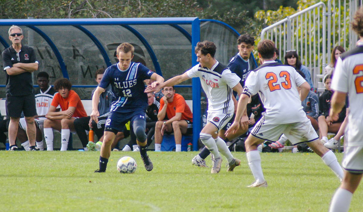 Blues defender Julian Denham-Rohlicek fends off Langara College attackers Sunday during a 3-0 setback at home to the Falcons.