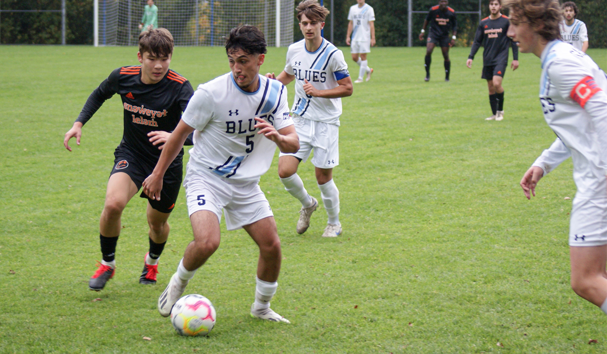 Blues midfielder Alex Lopez fends off a Langara College Falcons challenger as part of Sunday's 2-0 win to finish up the season.