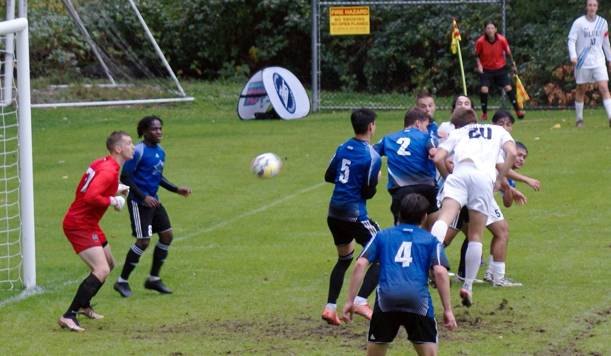 Riley Marshall (20) finishes a header off a corner from Tommy Millar, the first goal of the day on the way to a 2-1 Blues home win over Vancouver Island University.