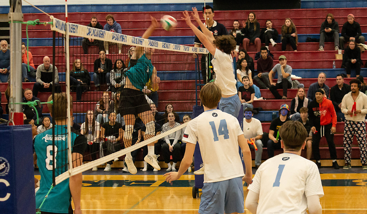 Blues setter Jonah Violini gets up at the net as COTR's Gustavo Bertoli takes a big swing Saturday in a 3-2 COTR victory.