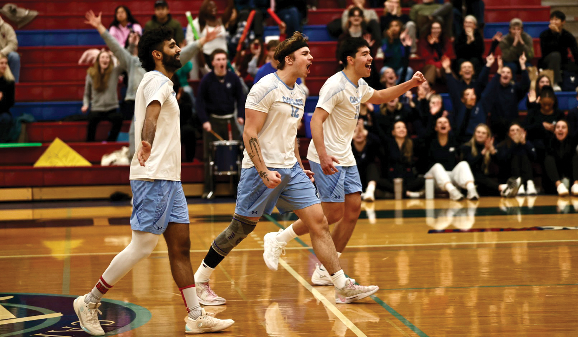 Blues men's volleyball players (from left) Shub Wander, Reese Nowotny and Brayden Labossiere celebrate a point as part of a five-set win Jan. 9 over Douglas College.