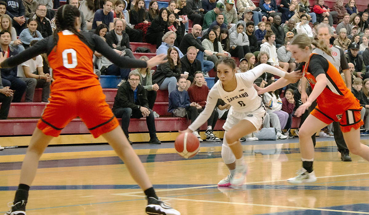 Blues point guard Kirsten Abo dribbles past a Langara defender on the opening night for Capilano basketball Oct. 20 at CapU's Centre for Sport and Wellness.