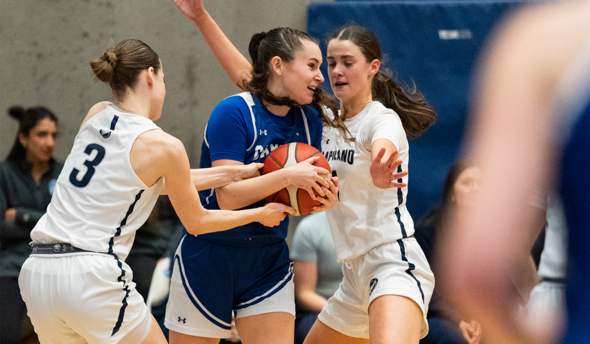 Barcha Hnizdilova (3) and Jade de Fondaumiere surround a Camosun ballhandler Thursday during a 63-41 Blues win in the PACWEST quarter-final. (Athena Pimental photo)