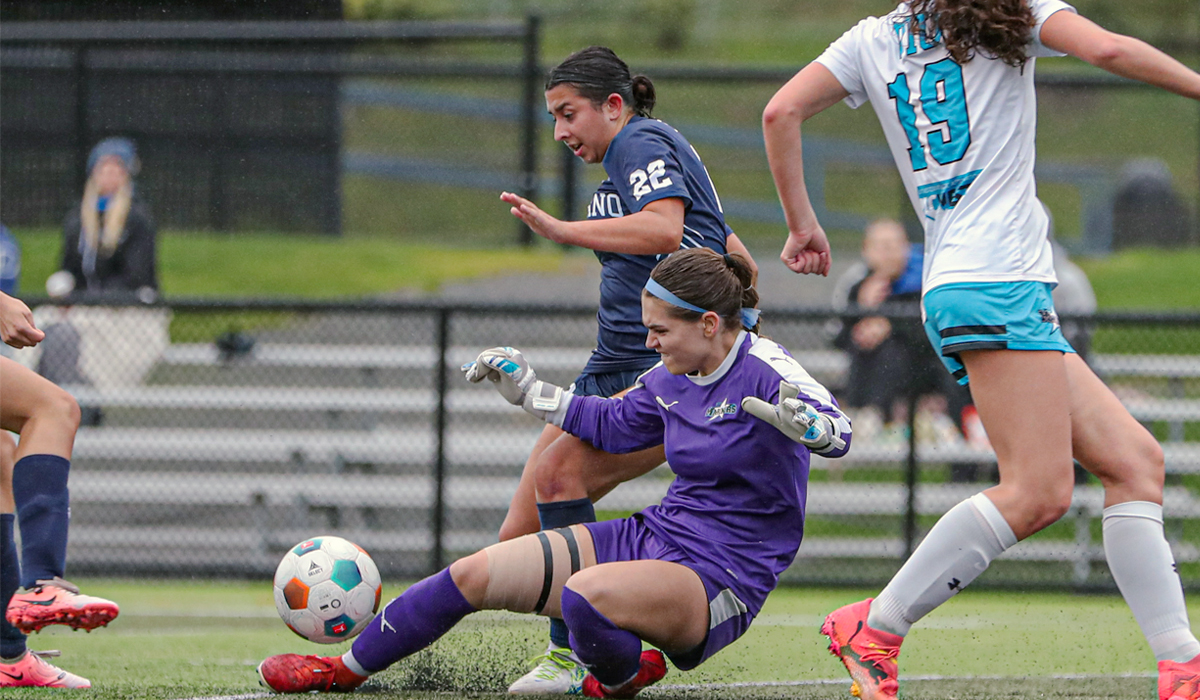 Sophie Pather (22) battles for the ball with VIU keeper Kaiden Thorpe during a 3-0 setback Oct. 19 for the Blues. (Matt Carter/VIU Athletics)
