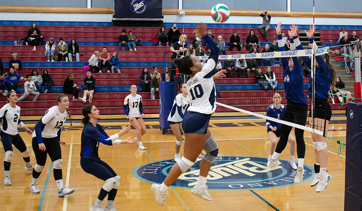 Nnya Mbaoma takes a swing against a tandem block from Camosun College during a straight-sets Blues win Friday, Nov. 3 at CapU.