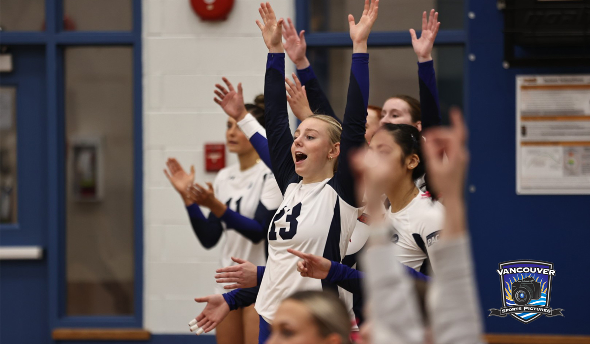 Sophie Yarish (centre) and teammates react to a Blues point Friday night during a straight-sets win over Columbia Bible College at CapU's Centre for Sport and Wellness.
